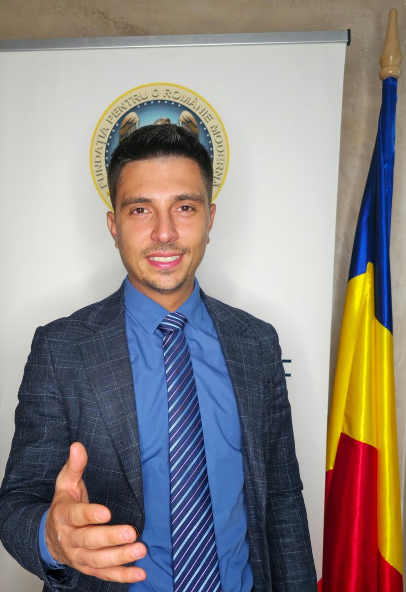 Reprezentant FPRM lângă roll-up-ul Fundației și drapel